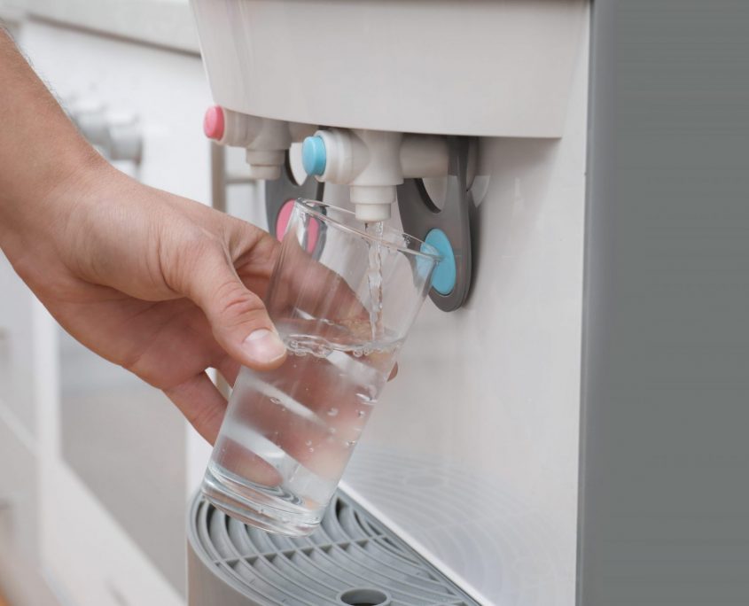 Erogatore d'acqua moderno con bicchiere - Aurora D'Agostino - Twister Adv Mano che riempie un bicchiere di vetro con acqua fresca da un erogatore e dispensatore moderno per Aurora D'Agostino.