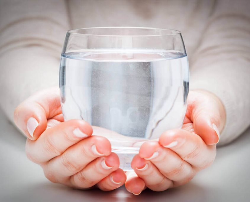 Bicchiere d'acqua pura sostenuto tra le mani - Aurora D'Agostino - Twister Adv Mani femminili che tengono delicatamente un bicchiere trasparente colmo d'acqua pura per Aurora D'Agostino.