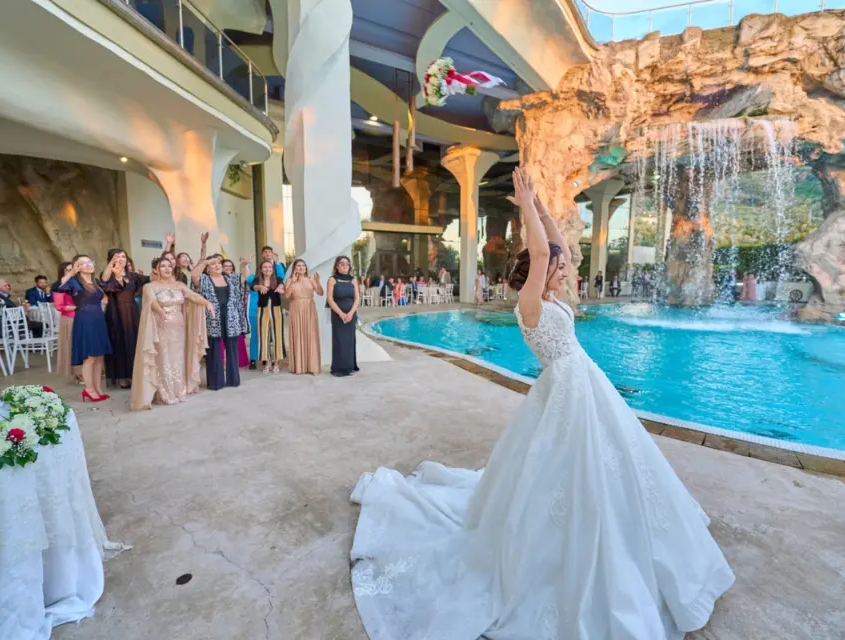Sala Madame Lillà - Location per Ricevimenti ed Eventi Sposa con lancio del bouquet a bordo piscina con cascata durante un matrimonio presso Sala Madame Lillà